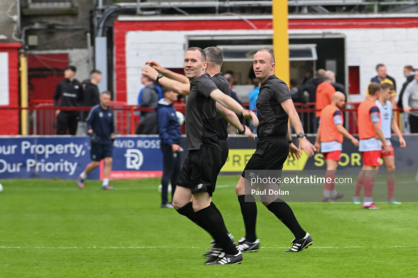 Whistle blares, match paused, Cards flash under the floodlights, Judgement held in hands.