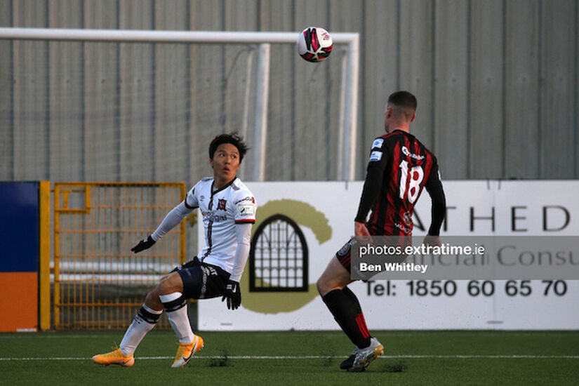 Han Jeongwoo and James Finnerty compete for the ball in Oriel Park
