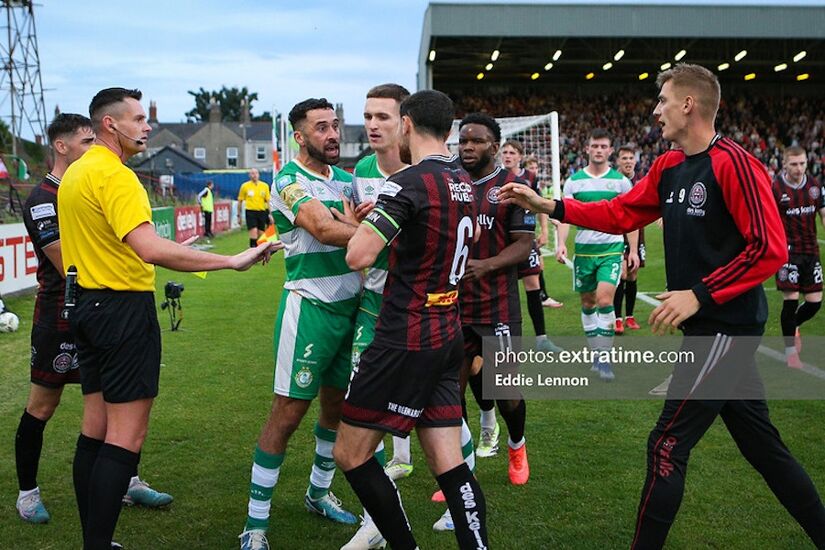 Referee Rob Harvey in yellow looking to calm things down as Rovers and Bohs players have a rush of blood to the head after some trouble in the Hoops penalty area