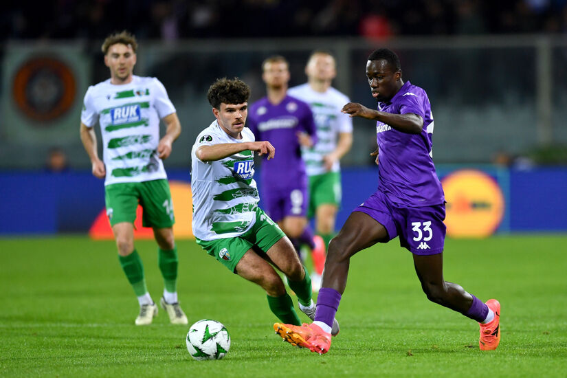 Michael Kayode of Fiorentina runs with the ball under pressure from Ben Clark of The New Saints during the UEFA Conference League 2024/25 League Phase MD1 match between ACF Fiorentina and The New Saints FC at  on October 03, 2024 in Florence, Italy.