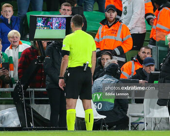 Referee Rade Obrenovic reviewing penalty incident in UEFA Nations League game between the Republic of Ireland and Armenia