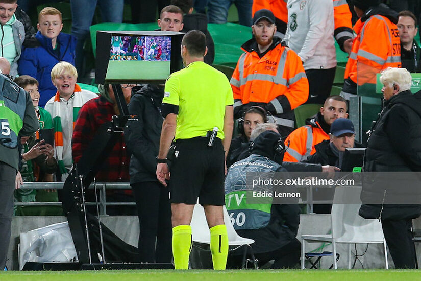 Referee Rade Obrenovic reviewing penalty incident in UEFA Nations League game between the Republic of Ireland and Armenia