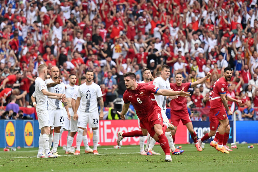 MUNICH, GERMANY - JUNE 20: Luka Jovic of Serbia celebrates scoring his team's first goal as players of Slovenia react during the UEFA EURO 2024 group stage match between Slovenia and Serbia at Munich Football Arena on June 20, 2024 in Munich, Germany.
