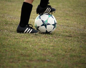 Football Black boots standing on ball