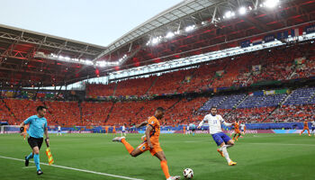 Denzel Dumfries of the Netherlands crosses the ball whilst under pressure from Theo Hernandez of France during the UEFA EURO 2024 group stage match between Netherlands and France at Football Stadium Leipzig on June 21, 2024 in Leipzig