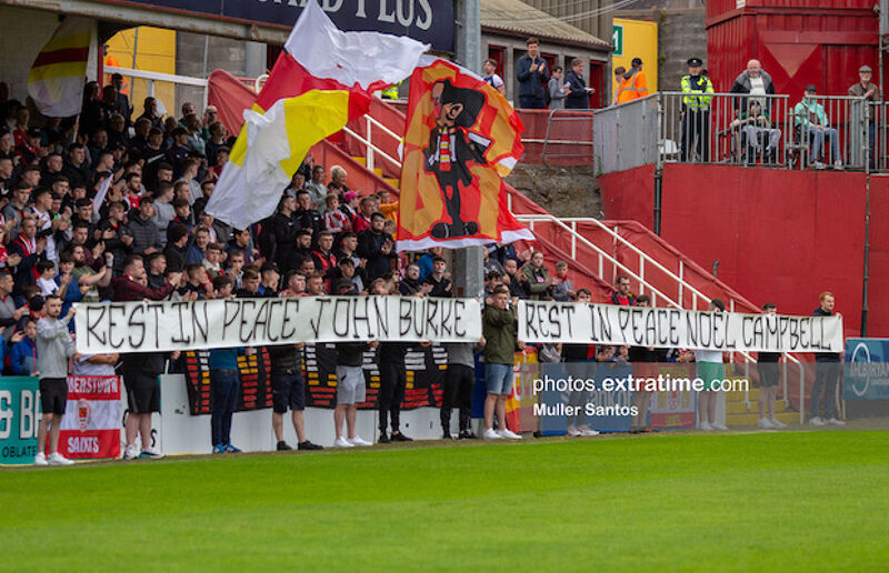 Saints supporters display banners remembering John Burke and Noel Campbell who both died during the week